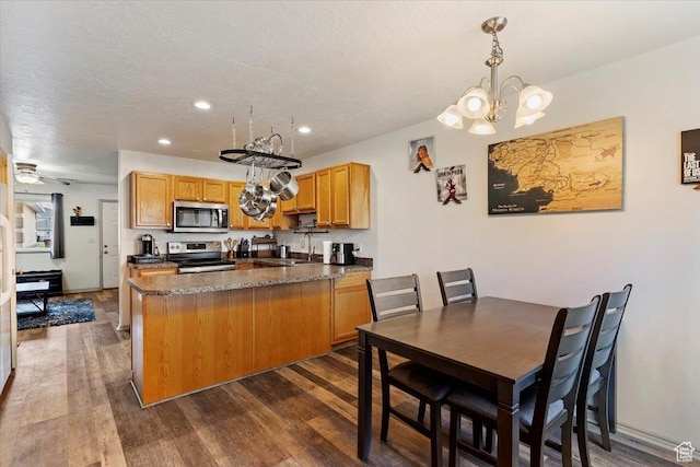 228 W 1975 N Unit 56, Harrisville, UT 84414 - kitchen featuring stainless steel appliances, dark wood-type flooring, dark countertops, a chandelier, and a textured ceiling