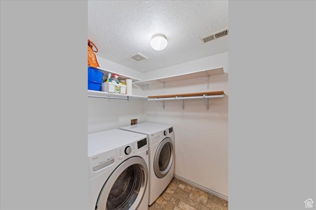 228 W 1975 N Unit 56, Harrisville, UT 84414 - laundry area featuring washer and clothes dryer, a textured ceiling, and stone finish floors