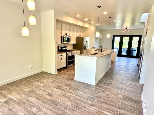 4843 W S Jordan Pkwy S, South Jordan, UT 84009 - kitchen with stainless steel appliances, french doors, a spacious island, wood finished floors, and recessed lighting