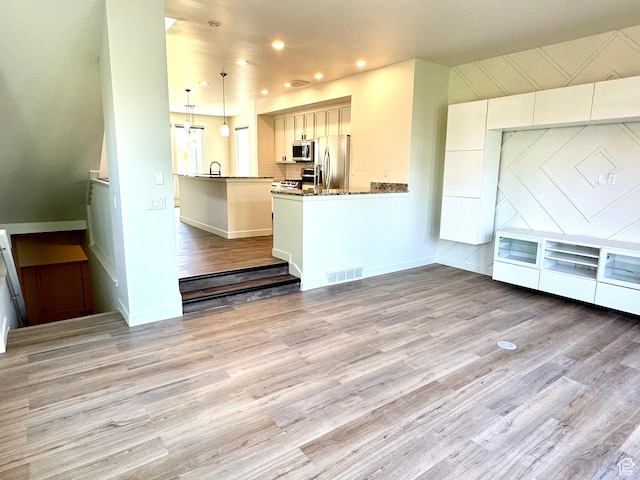 4843 W S Jordan Pkwy S, South Jordan, UT 84009 - kitchen with stainless steel appliances, light wood-style floors, recessed lighting, hanging light fixtures, and a peninsula