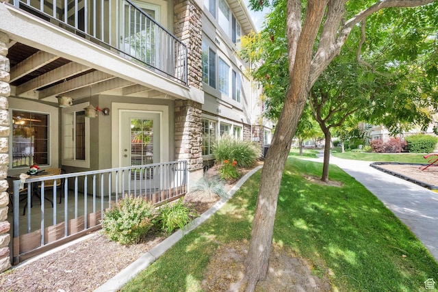 1225 W Dallin Dr Unit Q102, Pleasant Grove, UT 84062 - view of home's exterior with stone siding, a balcony, and a lawn