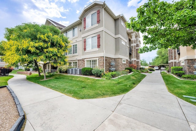1225 W Dallin Dr Unit Q102, Pleasant Grove, UT 84062 - view of side of property with stucco siding, stone siding, and a lawn