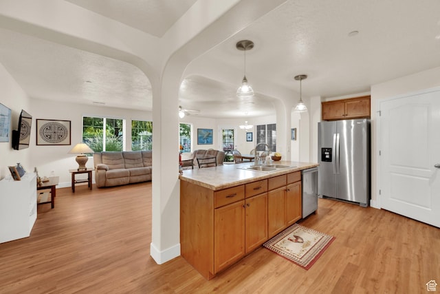 1225 W Dallin Dr Unit Q102, Pleasant Grove, UT 84062 - kitchen with appliances with stainless steel finishes, open floor plan, light wood-style floors, light countertops, and arched walkways