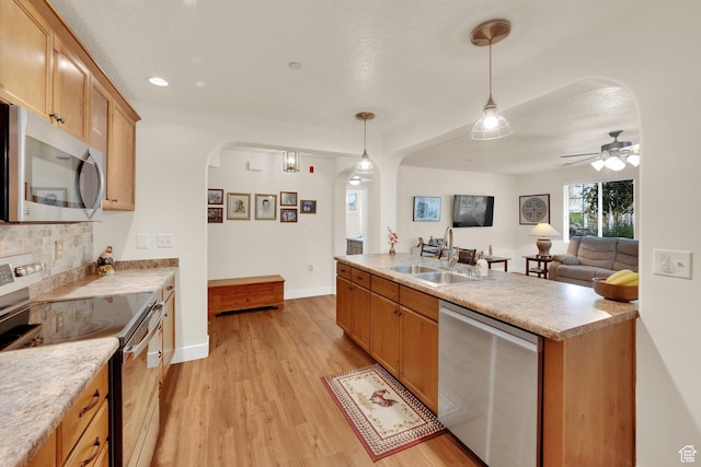 1225 W Dallin Dr Unit Q102, Pleasant Grove, UT 84062 - kitchen with stainless steel appliances, arched walkways, light wood-style floors, decorative light fixtures, and tasteful backsplash