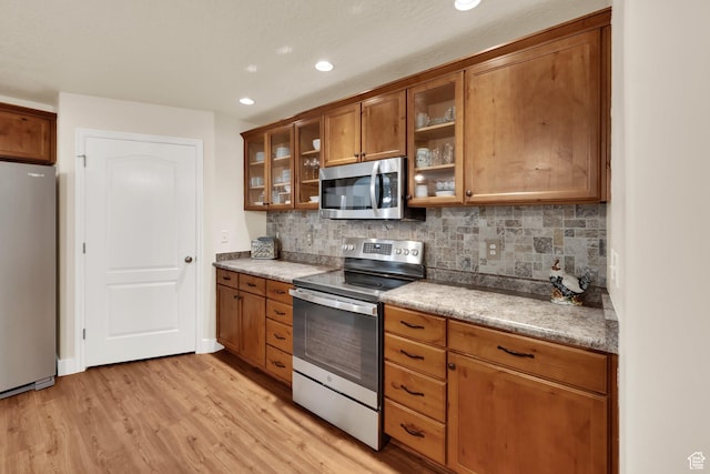 1225 W Dallin Dr Unit Q102, Pleasant Grove, UT 84062 - kitchen with appliances with stainless steel finishes, brown cabinetry, light wood finished floors, decorative backsplash, and recessed lighting