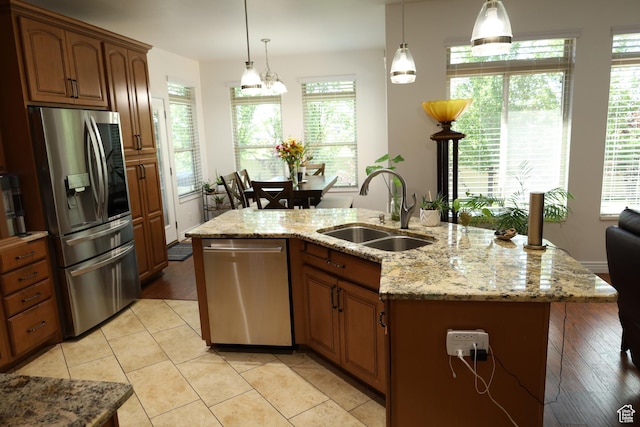 2681 N 3375 W, Plain City, UT 84404 - kitchen featuring stainless steel appliances, pendant lighting, light stone counters, and a kitchen island with sink