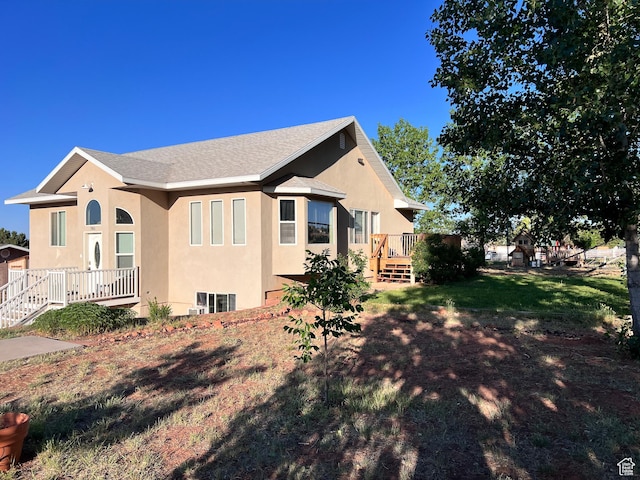 785 N Homestead St, Hildale, UT 84784 - view of property exterior with stucco siding, a deck, roof with shingles, and a lawn