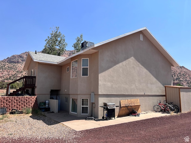 785 N Homestead St, Hildale, UT 84784 - back of property with a mountain view, stucco siding, stairs, and a patio area