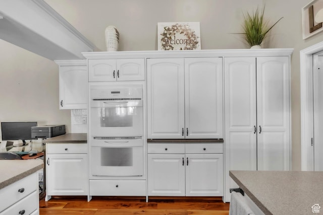 1630 N Camelot Dr E, North Logan, UT 84341 - kitchen featuring white double oven, white cabinetry, and wood finished floors