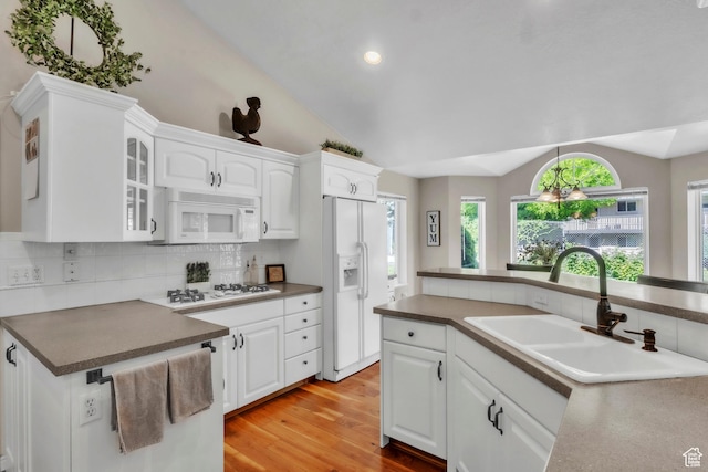 1630 N Camelot Dr E, North Logan, UT 84341 - kitchen with white appliances, lofted ceiling, decorative backsplash, white cabinetry, and light wood finished floors