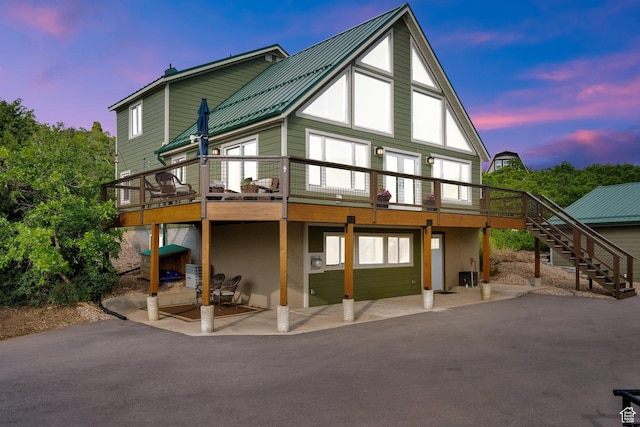 1719 Clyde Lake Dr Unit 346, Heber City, UT 84032 - back of house at dusk with stairway, a patio, a deck, a metal roof, and stucco siding