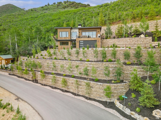 1400 Weber Wild Rd, Oakley, UT 84055 - view of front facade with a forest view, a balcony, a chimney, and a mountain view