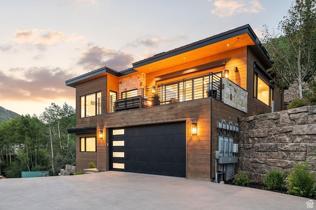 1400 Weber Wild Rd, Oakley, UT 84055 - contemporary house with a balcony, an attached garage, driveway, and stone siding