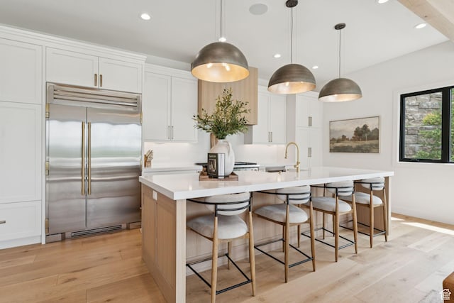 1400 Weber Wild Rd, Oakley, UT 84055 - kitchen with built in refrigerator, light wood-type flooring, a kitchen island with sink, white cabinetry, and light countertops