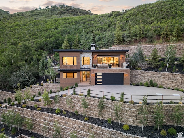 1400 Weber Wild Rd, Oakley, UT 84055 - view of front facade featuring a wooded view, driveway, a garage, and a balcony