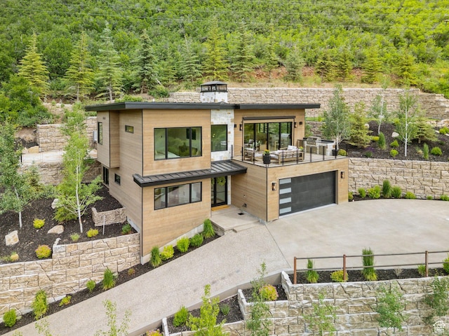 1400 Weber Wild Rd, Oakley, UT 84055 - contemporary house with a forest view, concrete driveway, a standing seam roof, an attached garage, and a metal roof