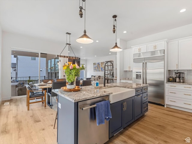 5796 N Valley View Rd, Lehi, UT 84043 - kitchen featuring appliances with stainless steel finishes, white cabinetry, light wood-style flooring, a kitchen island with sink, and recessed lighting
