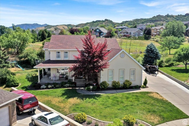 955 Mink Cir N, Salt Lake, UT 84054 - view of front of home with covered porch, stucco siding, a mountain view, a front lawn, and a residential view