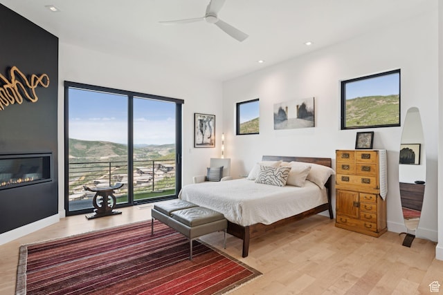 11515 N White Tail Ct, Hideout, UT 84036 - bedroom with light wood-style flooring, access to outside, recessed lighting, a glass covered fireplace, and ceiling fan