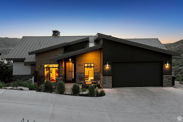 11515 N White Tail Ct, Hideout, UT 84036 - contemporary home with a standing seam roof, a garage, concrete driveway, and stone siding