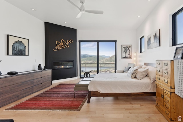11515 N White Tail Ct, Hideout, UT 84036 - bedroom with a mountain view, light wood finished floors, a large fireplace, recessed lighting, and access to outside