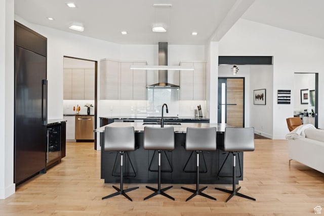 11515 N White Tail Ct, Hideout, UT 84036 - kitchen featuring wall chimney exhaust hood, modern cabinets, paneled built in fridge, a kitchen breakfast bar, and recessed lighting