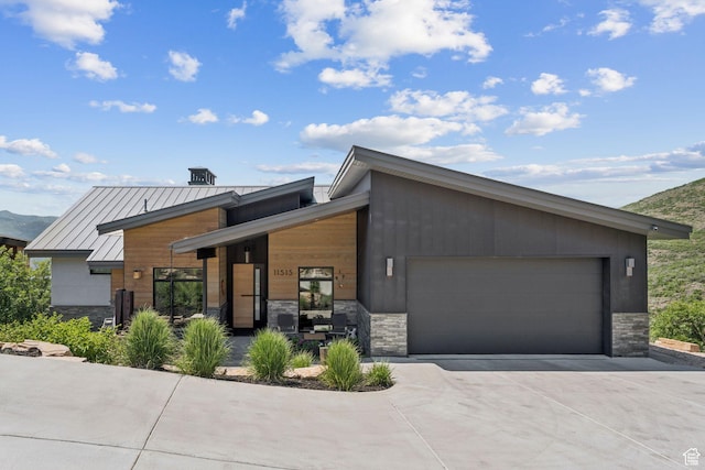 11515 N White Tail Ct, Hideout, UT 84036 - contemporary house featuring stone siding, driveway, an attached garage, a standing seam roof, and a metal roof
