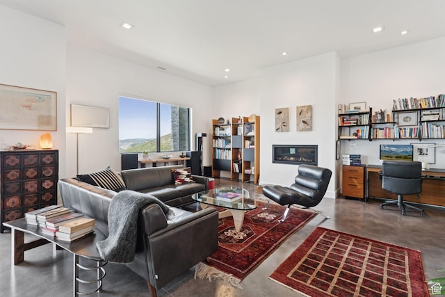11515 N White Tail Ct, Hideout, UT 84036 - living area featuring concrete floors, a glass covered fireplace, recessed lighting, and built in desk