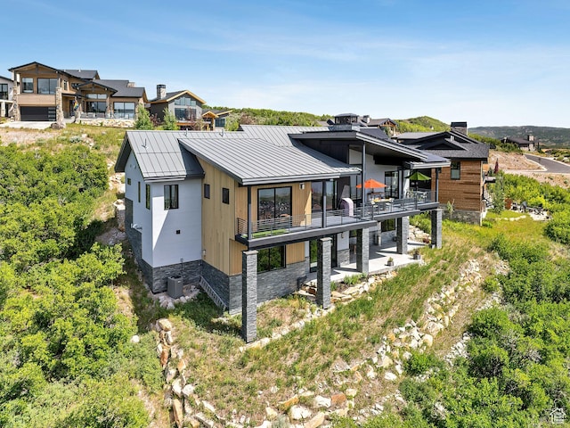 11515 N White Tail Ct, Hideout, UT 84036 - rear view of house featuring a balcony, a standing seam roof, a metal roof, and a patio