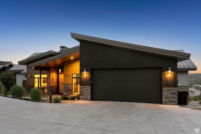 11515 N White Tail Ct, Hideout, UT 84036 - view of front facade featuring stone siding, a standing seam roof, a garage, and a metal roof