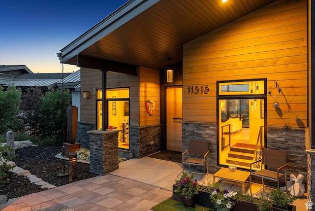 11515 N White Tail Ct, Hideout, UT 84036 - exterior entry at dusk featuring stone siding and covered porch