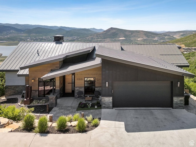 11515 N White Tail Ct, Hideout, UT 84036 - modern home featuring a standing seam roof, a mountain view, stone siding, and an attached garage