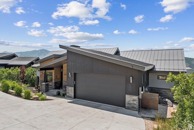 11515 N White Tail Ct, Hideout, UT 84036 - modern home with an attached garage, a metal roof, a standing seam roof, and stone siding