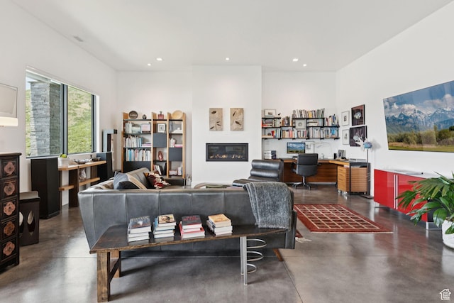 11515 N White Tail Ct, Hideout, UT 84036 - living room with concrete floors, a desk, recessed lighting, and a glass covered fireplace