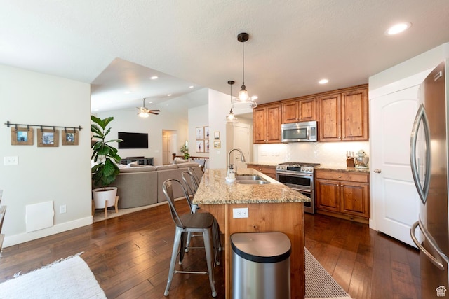 2071 S 500 E, Heber City, UT 84032 - kitchen with stainless steel appliances, a ceiling fan, light stone countertops, brown cabinets, and dark wood finished floors