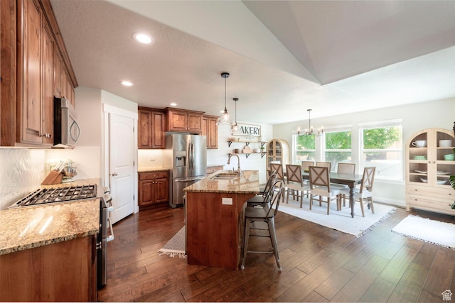 2071 S 500 E, Heber City, UT 84032 - kitchen featuring stainless steel appliances, brown cabinets, a kitchen breakfast bar, light stone counters, and a chandelier