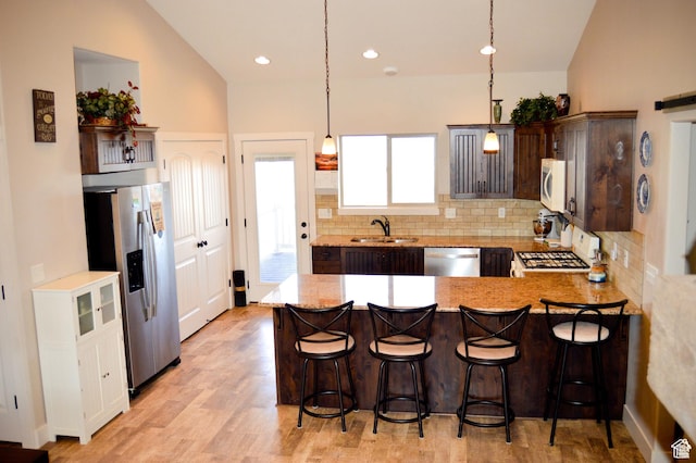 2070 S Sweetwater Parkway Park E Unit 33, Garden City, UT 84028 - kitchen with stainless steel appliances, backsplash, a peninsula, vaulted ceiling, and a breakfast bar area
