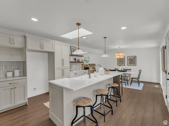 1432 E Colony Dr, Holladay, UT 84117 - kitchen with open shelves, a skylight, a kitchen bar, decorative backsplash, and wood finished floors