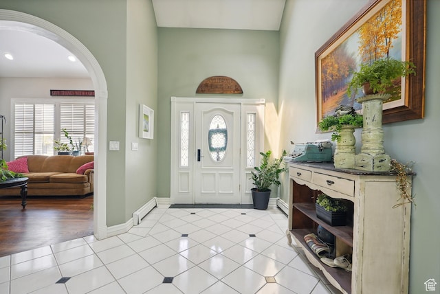 12671 S Somerdowns Ct, Draper, UT 84020 - entrance foyer featuring a towering ceiling, arched walkways, light tile patterned floors, and a baseboard radiator