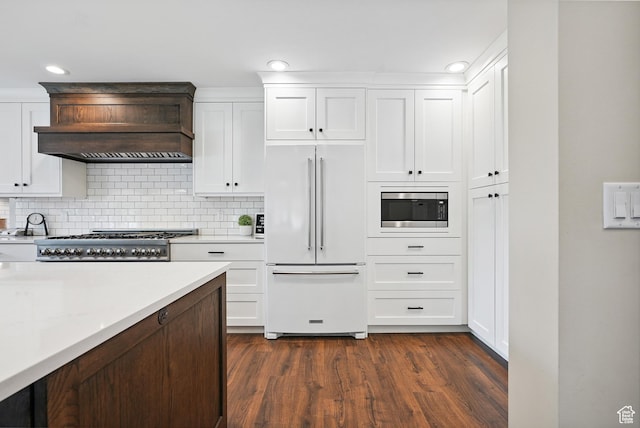 12671 S Somerdowns Ct, Draper, UT 84020 - kitchen featuring built in appliances, custom exhaust hood, light countertops, white cabinetry, and recessed lighting