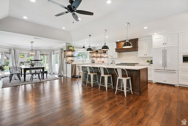 12671 S Somerdowns Ct, Draper, UT 84020 - kitchen with built in appliances, open shelves, light countertops, a breakfast bar area, and decorative backsplash