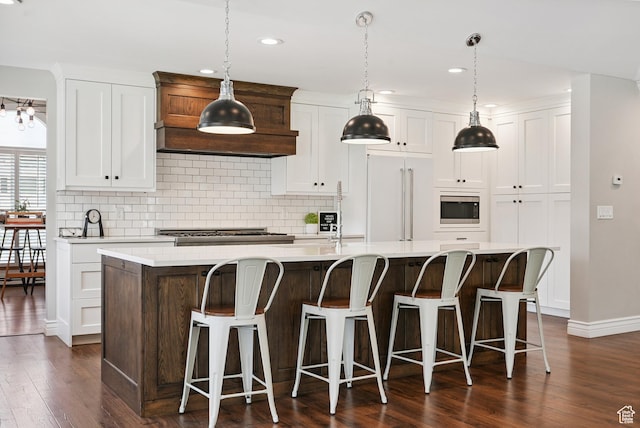 12671 S Somerdowns Ct, Draper, UT 84020 - kitchen featuring built in appliances, dark wood finished floors, a center island with sink, decorative backsplash, and recessed lighting