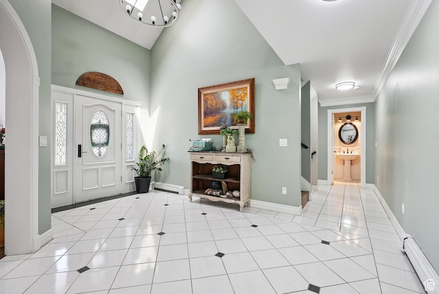 12671 S Somerdowns Ct, Draper, UT 84020 - entrance foyer featuring baseboard heating, a chandelier, light tile patterned floors, crown molding, and arched walkways