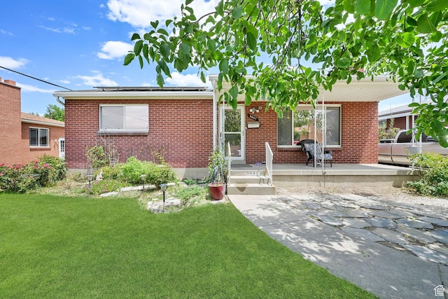 3347 S Rulon St W, Magna, UT 84044 - view of front of house featuring brick siding, a front lawn, and a porch