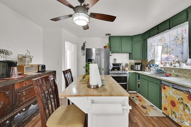 3347 S Rulon St W, Magna, UT 84044 - kitchen with green cabinetry, stainless steel appliances, light wood finished floors, a ceiling fan, and butcher block countertops