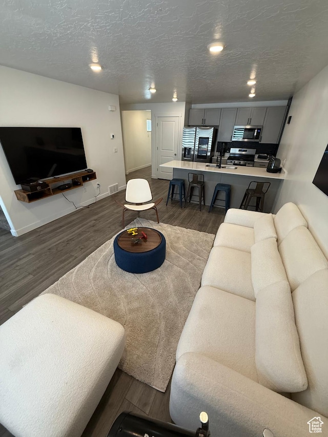 1144 E Trident Dr S, Saratoga Springs, UT 84045 - living area with dark wood-style floors, recessed lighting, and a textured ceiling