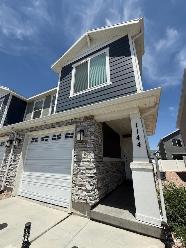 1144 E Trident Dr S, Saratoga Springs, UT 84045 - view of front of home with stone siding, concrete driveway, and an attached garage