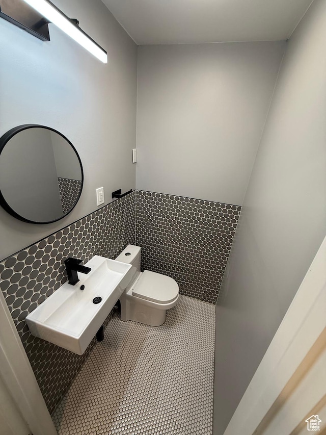 1144 E Trident Dr S, Saratoga Springs, UT 84045 - half bath featuring tile walls, a wainscoted wall, and tile patterned floors