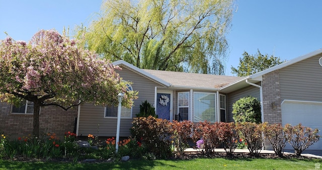 5149 W Village Wood Dr, West Valley City, UT 84120 - view of front facade with brick siding and an attached garage