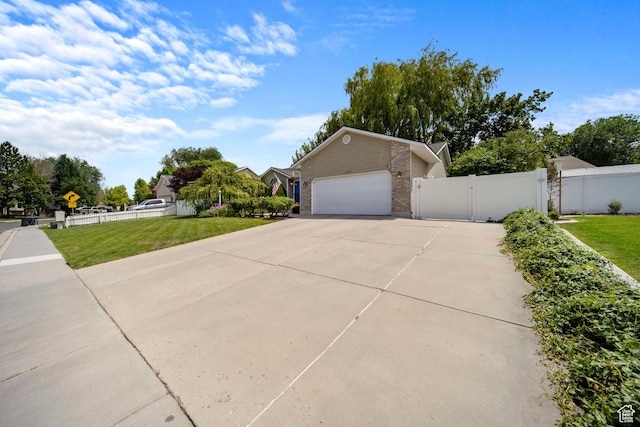 5149 W Village Wood Dr, West Valley City, UT 84120 - view of front of property with driveway, an attached garage, brick siding, and a gate